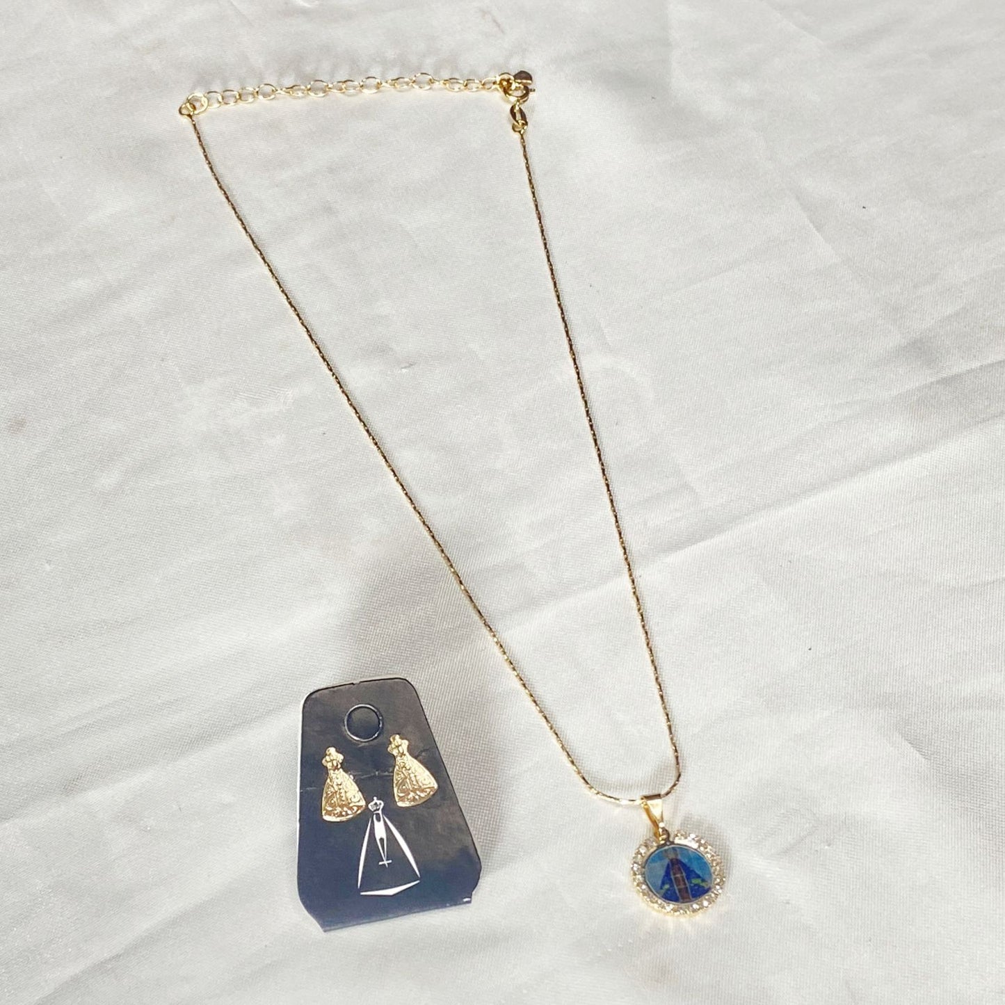 CORRENTE DOURADA COM BRINCO NOSSA SENHORA APARECIDA COM STRASS BRANCO ( 1 UNIDADE)