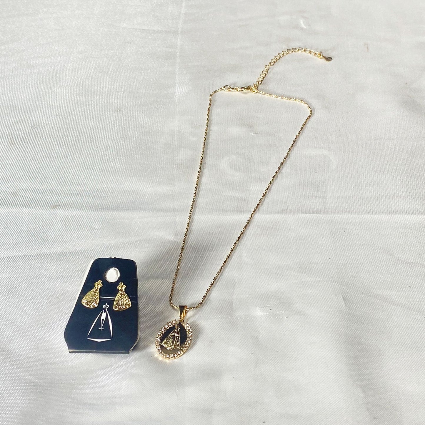 CORRENTE DOURADA COM BRINCO NOSSA SENHORA APARECIDA EM RELEVO COM STRASS BRANCO ( 1 UNIDADE)