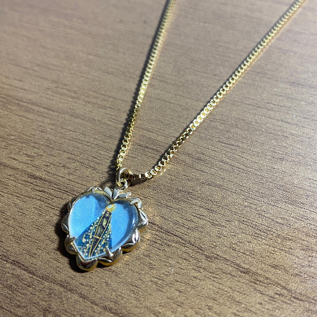 CORRENTE DOURADA COM PINGENTE CORAÇÃO RESINADO NOSSA SENHORA APARECIDA ( 1 UNIDADE)