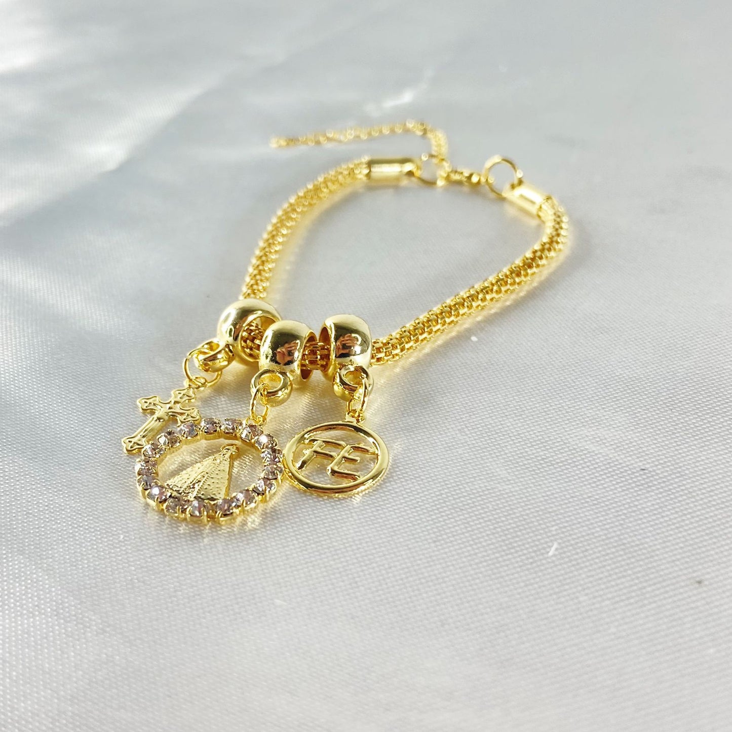 PULSEIRA DOURADA REDONDA NOSSA SENHORA APARECIDA COM STRASS BRANCO (6 UNIDADES)