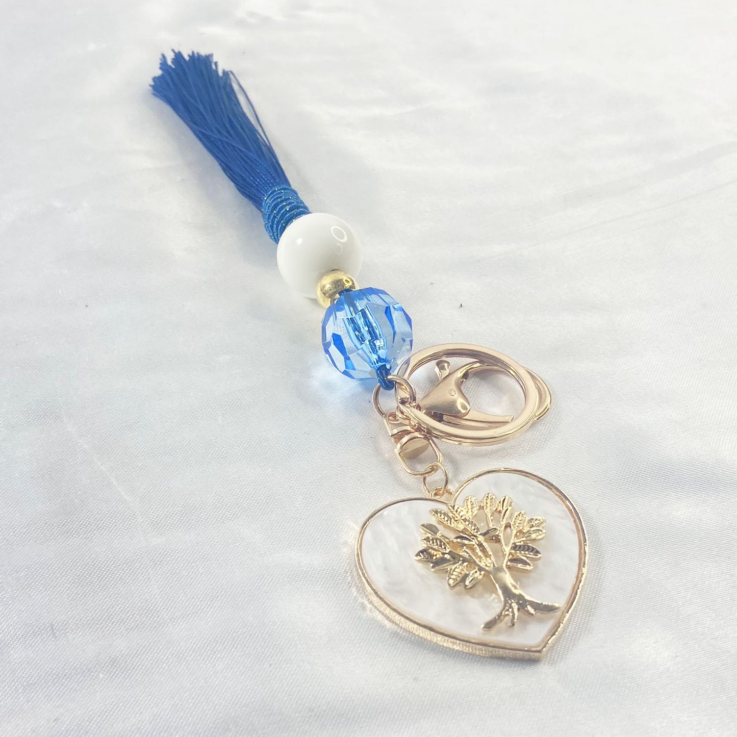 CHAVEIRO LUXO COM MOSQUETE ÁRVORE DA VIDA COM POMPOM AZUL (1 UNIDADE)