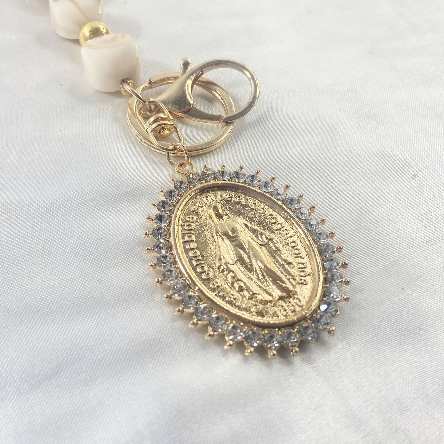 CHAVEIRO LUXO COM MOSQUETE NOSSA SENHORA DAS GRAÇAS COM POMPOM BEGE (1 UNIDADE)