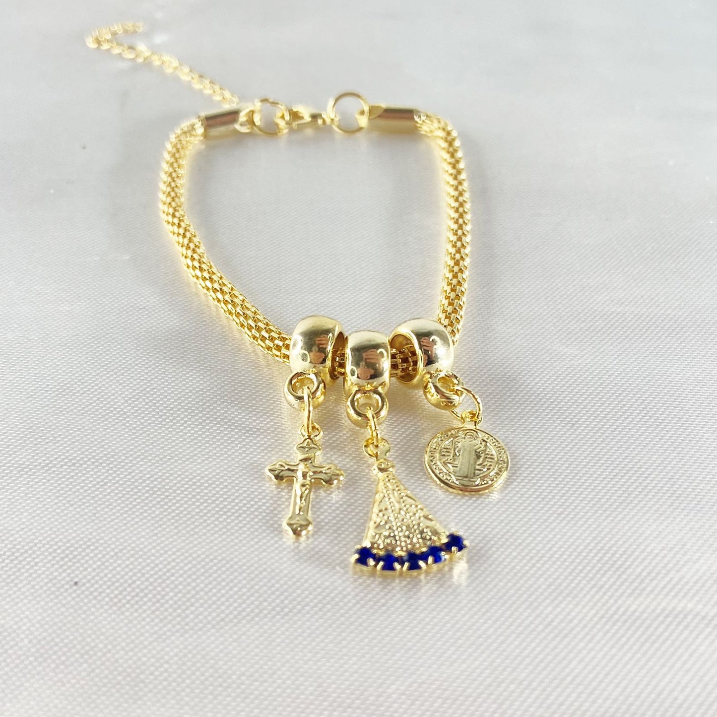 PULSEIRA DOURADA NOSSA SENHORA APARECIDA COM STRASS AZUL (6 UNIDADES)