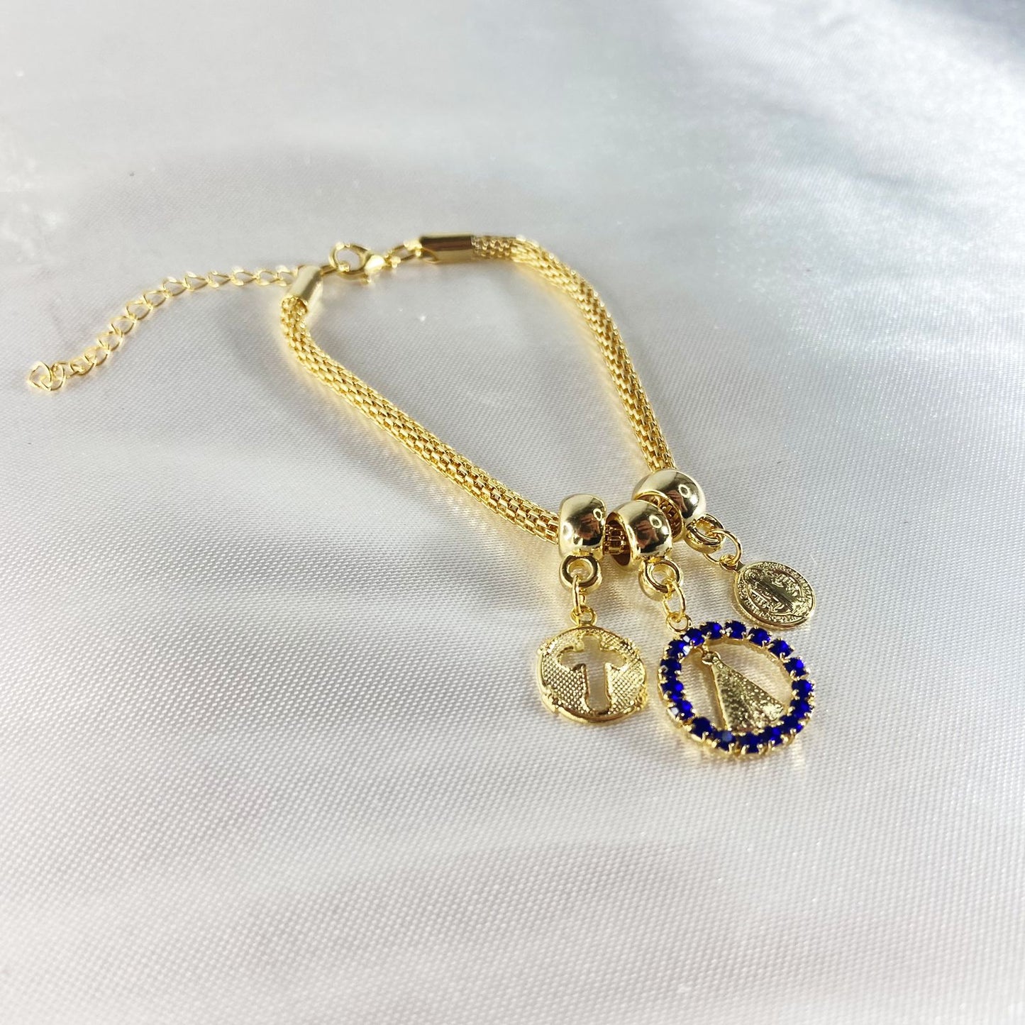 PULSEIRA DOURADA REDONDA NOSSA SENHORA APARECIDA COM STRASS AZUL (6 UNIDADES)
