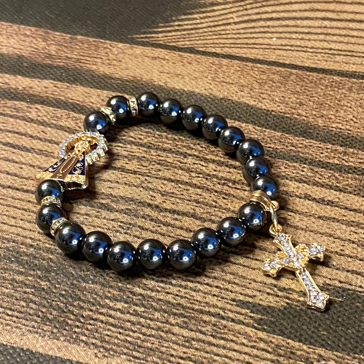 PULSEIRA HEMATITA NOSSA SENHORA APARECIDA COM PINGENTE DE CRUZ  08MM (06 UNIDADES)