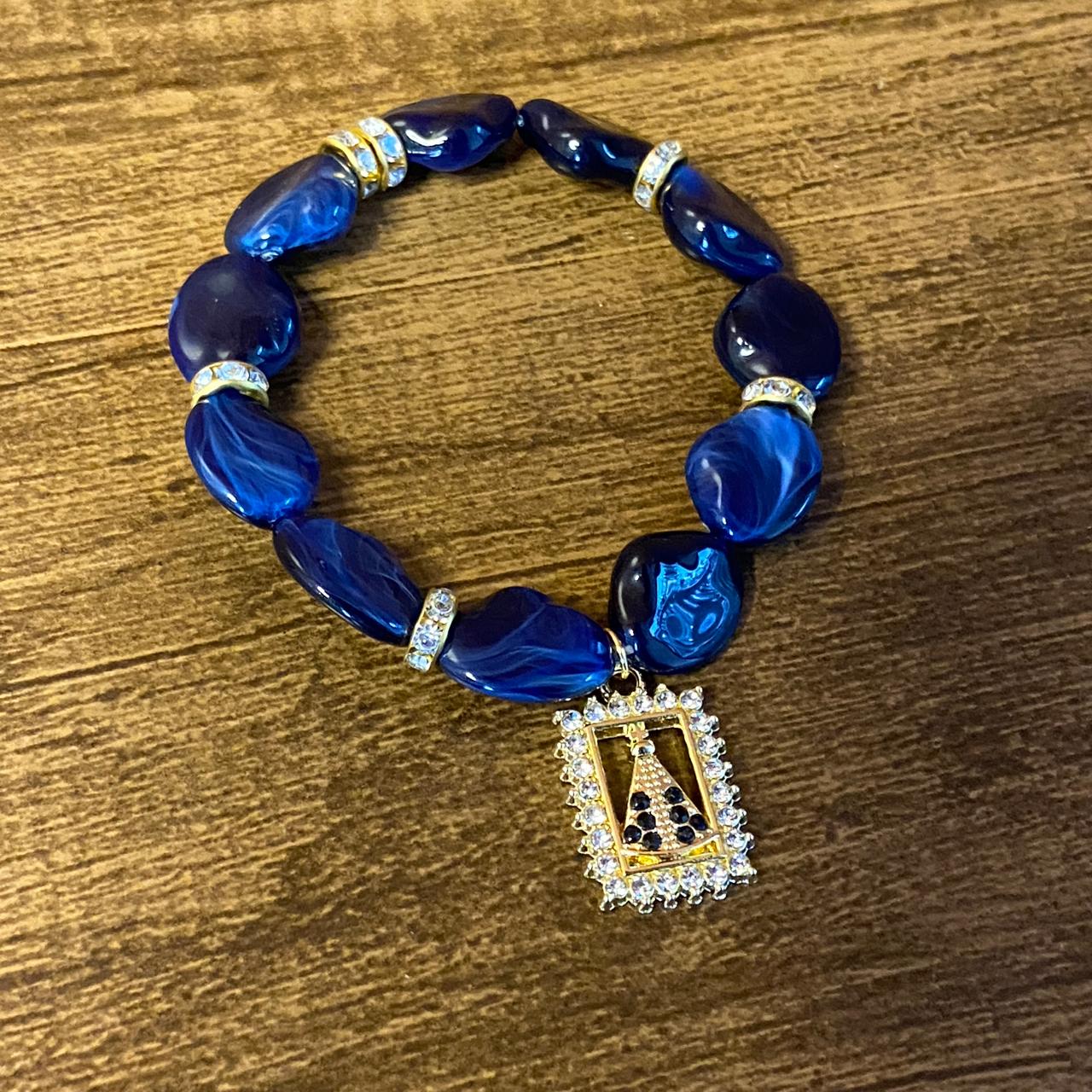 PULSEIRA PEDRARIAS COM PINGENTE NOSSA SENHORA APARECIDA COM STRASS (03 UNIDADES)