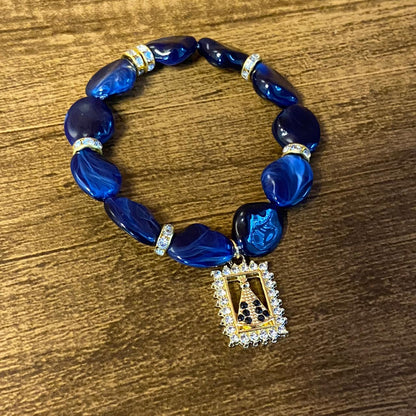 PULSEIRA PEDRARIAS COM PINGENTE NOSSA SENHORA APARECIDA COM STRASS (03 UNIDADES)