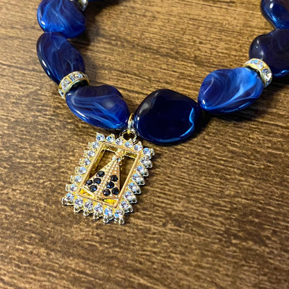 PULSEIRA PEDRARIAS COM PINGENTE NOSSA SENHORA APARECIDA COM STRASS (03 UNIDADES)