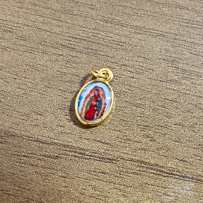 PINGENTE DOURADO OVAL RESINADO NOSSA SENHORA DE GUADALUPE  (5 UNIDADES)