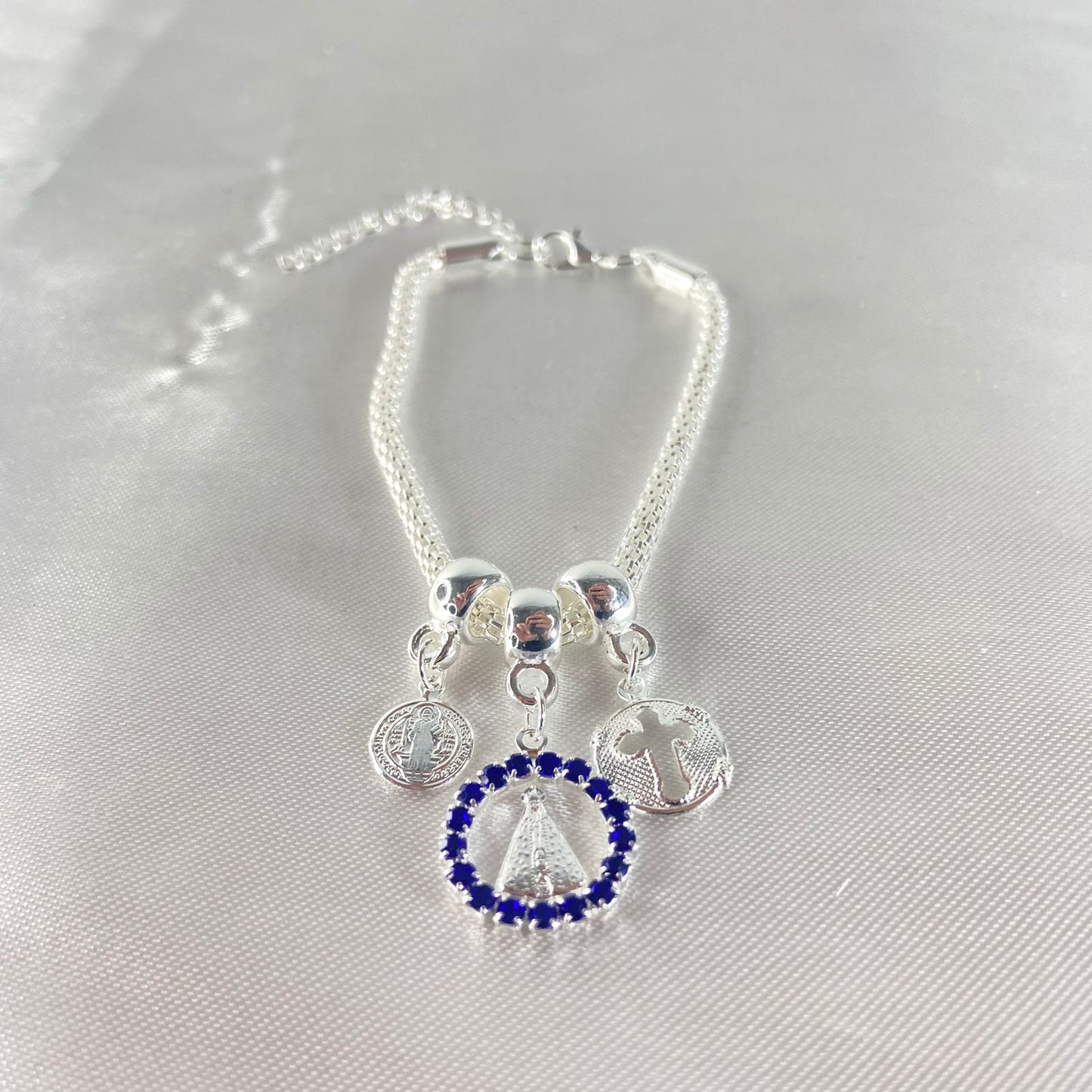 PULSEIRA NÍQUEL REDONDO NOSSA SENHORA APARECIDA COM STRASS AZUL (6 UNIDADES)