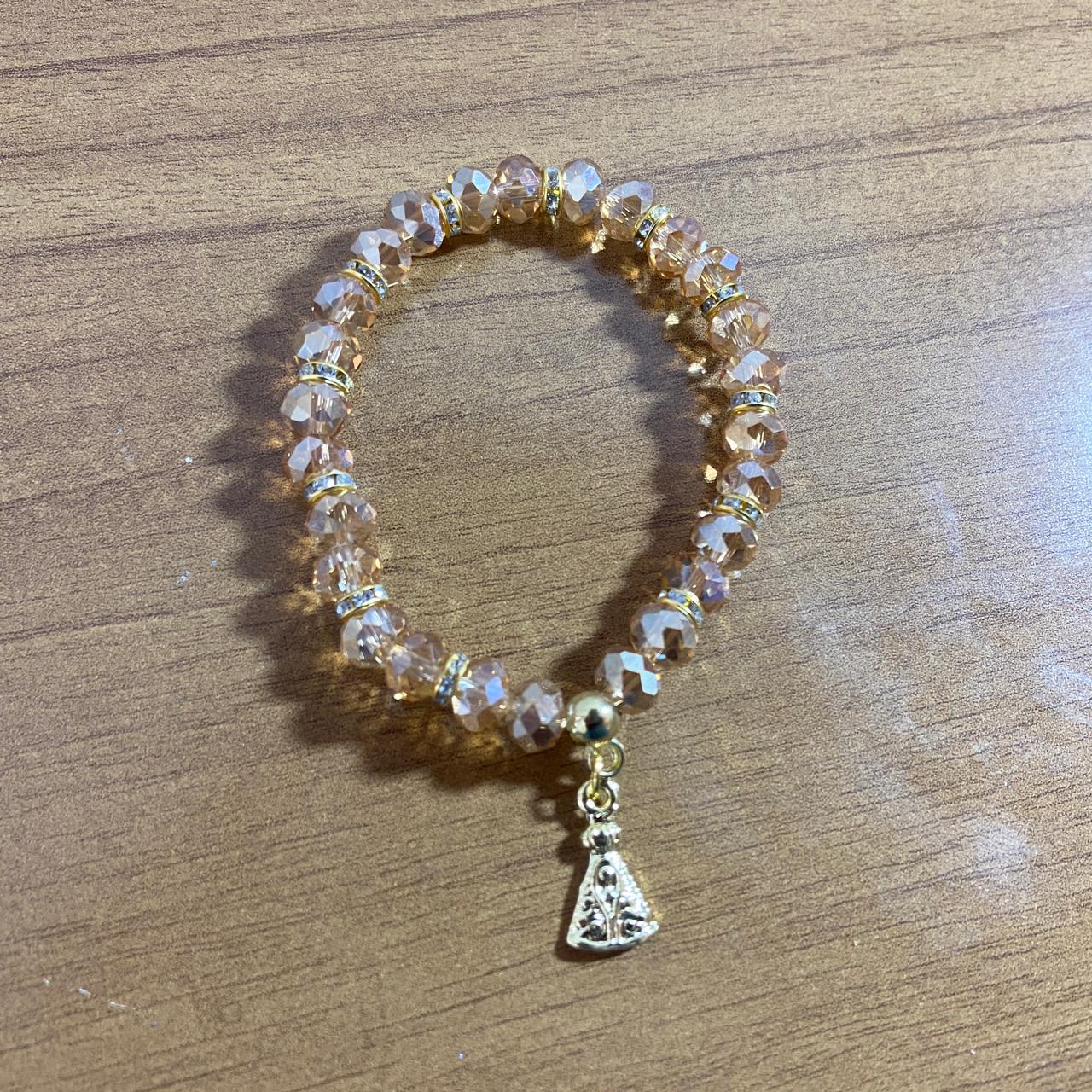 PULSEIRA CRISTAL BEGE TRANSPARENTE NOSSA SENHORA APARECIDA  (06 UNIDADES)
