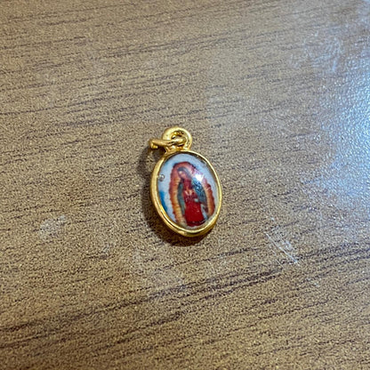 PINGENTE DOURADO OVAL RESINADO NOSSA SENHORA DE GUADALUPE  (5 UNIDADES)