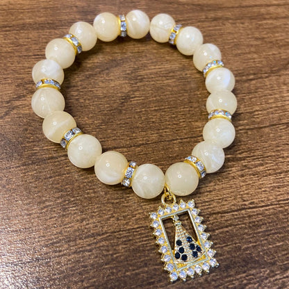 PULSEIRA PÉROLA BEGE COM PINGENTE NOSSA SENHORA APARECIDA COM STRASS 08MM  (03 UNIDADES)
