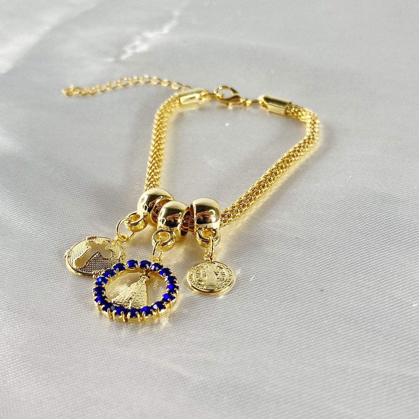 PULSEIRA DOURADA REDONDA NOSSA SENHORA APARECIDA COM STRASS AZUL  (6 UNIDADES)