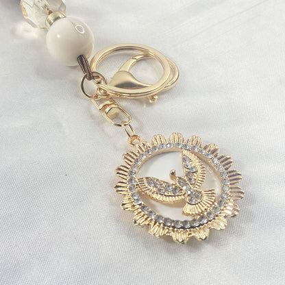 CHAVEIRO LUXO COM MOSQUETE DIVINO ESPÍRITO SANTO COM POMPOM MARROM (1 UNIDADE)